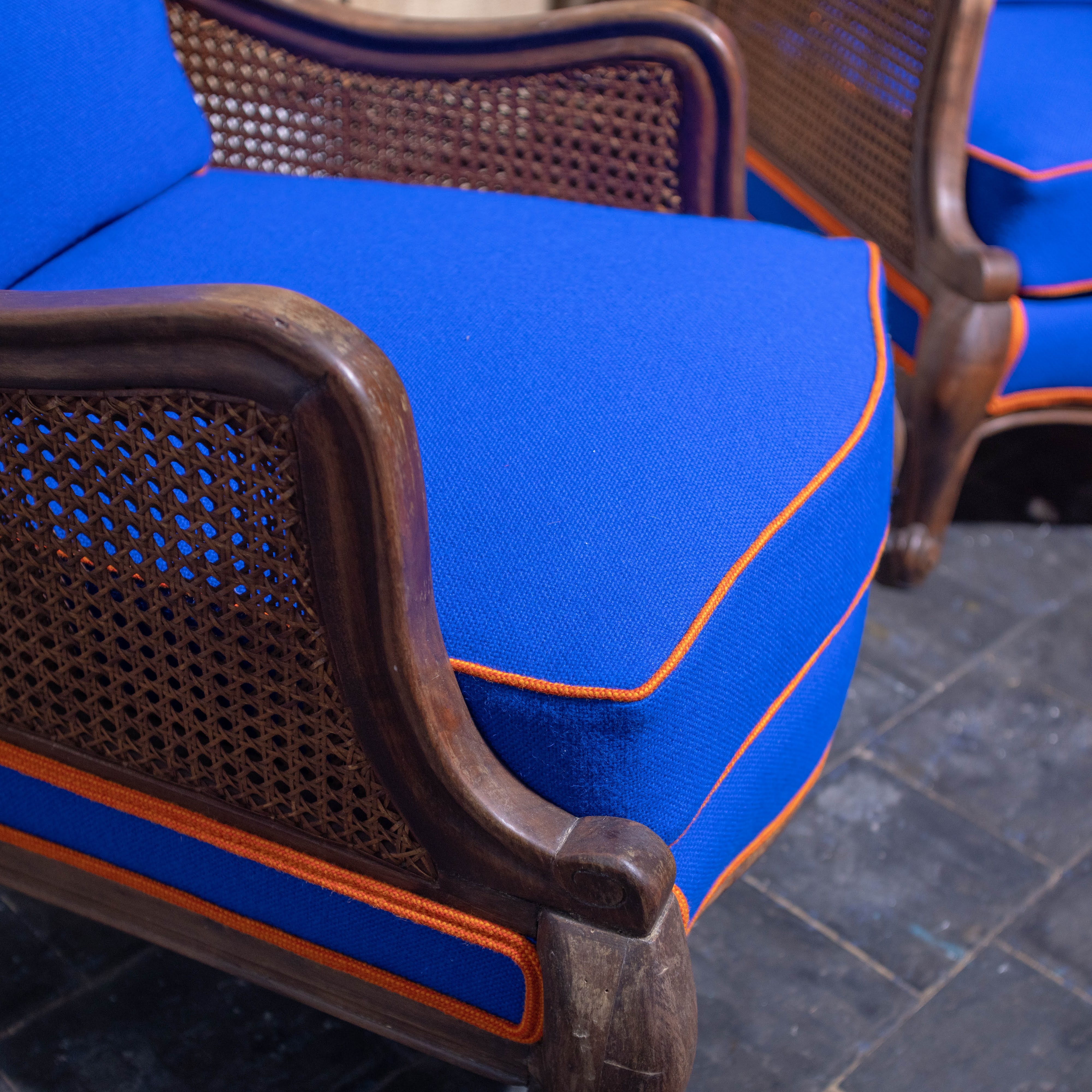 Een bruine stoel met blauwe kussens